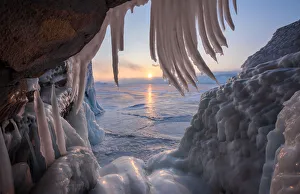 Ice stalactites in a cave at the shore at sunset at lake Baikal, Irkutsk region, Siberia Ice stalactites in a cave at the shore at sunset at lake Baikal, Irkutsk region, Siberia