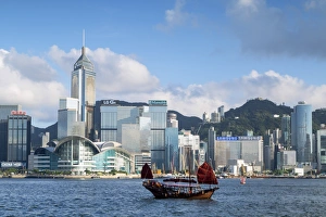 Junk boat passing Convention Centre and Hong Kong Island skyline, Hong Kong, China Junk boat passing Convention Centre and Hong Kong Island skyline, Hong Kong, China