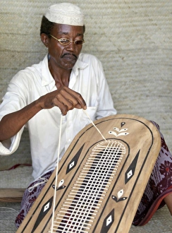 A Lamu man strings the back of a traditional Lamu-style A Lamu man strings the back of a traditional Lamu-style