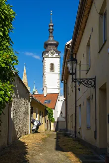 Lane towards tower of Church of the Nativity of the Blessed Virgin Mary on sunny day, Pisek, South Bohemian Region Lane towards tower of Church of the Nativity of the Blessed Virgin Mary on sunny day, Pisek, South Bohemian Region