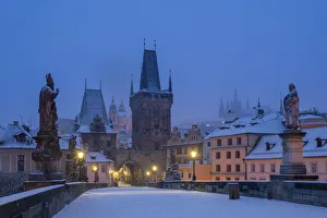 Mala Strana Bridge Tower at snow-covered Charles Bridge at twilight in winter, Prague Mala Strana Bridge Tower at snow-covered Charles Bridge at twilight in winter, Prague