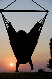 Malawi, Lake Malawi National Park. Young guest relaxes in a hammock at Pumulani Lodge Malawi, Lake Malawi National Park. Young guest relaxes in a hammock at Pumulani Lodge