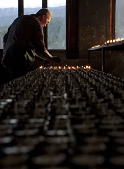 A man lighting candles in a temple in Bhutan A man lighting candles in a temple in Bhutan