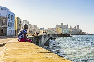 A man sitting and watching the ocean from the Malecon, La Habana Vieja (Old Town), Havana A man sitting and watching the ocean from the Malecon, La Habana Vieja (Old Town), Havana