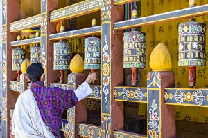 A man spinning prayer wheels in Trongsa Dzong, Trongsa District, Bhutan A man spinning prayer wheels in Trongsa Dzong, Trongsa District, Bhutan