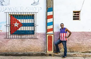 A man standing outside a barber shop in La Habana Vieja (Old Town), Havana, Cuba A man standing outside a barber shop in La Habana Vieja (Old Town), Havana, Cuba