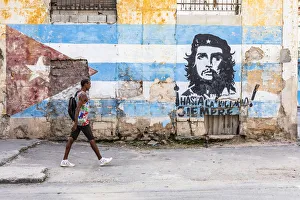 A man walking in a front of Che Guevara street art in La Habana Vieja (Old Town), Havana A man walking in a front of Che Guevara street art in La Habana Vieja (Old Town), Havana