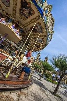 Merry-go-round with Ayuntamiento or Town Hall behind, Donostia San Sebastian, Gipuzkoa Merry-go-round with Ayuntamiento or Town Hall behind, Donostia San Sebastian, Gipuzkoa