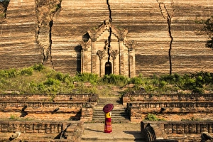 Mingun, Sagaing region, Myanmar (Burma). Woman with red umbrella looks at the Pahtodawgyi Mingun, Sagaing region, Myanmar (Burma). Woman with red umbrella looks at the Pahtodawgyi