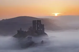 Mist below Corfe Castle at Sunrise, Dorset, England Mist below Corfe Castle at Sunrise, Dorset, England