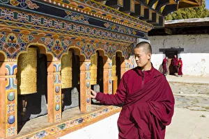 A monk spinning prayer wheels in Gangteng Monastery, Phobjikha Valley, Bhutan A monk spinning prayer wheels in Gangteng Monastery, Phobjikha Valley, Bhutan