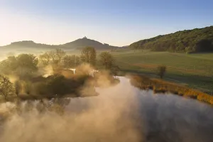 Morning mist over pond with Wachsenburg castle in the background Morning mist over pond with Wachsenburg castle in the background
