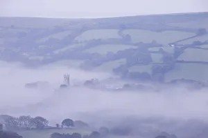 Morning mist swirls around the church tower of Widecombe in the Moor, Dartmoor, Devon Morning mist swirls around the church tower of Widecombe in the Moor, Dartmoor, Devon