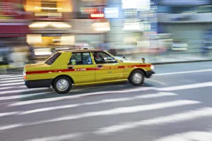 Motion blurred yellow taxi cab on pedestrian crossing, Tokyo, Japan Motion blurred yellow taxi cab on pedestrian crossing, Tokyo, Japan