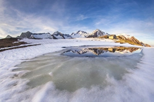 Mount Disgrazia and Corni Bruciati reflecting in the Lake Meltri in the thawing season Mount Disgrazia and Corni Bruciati reflecting in the Lake Meltri in the thawing season