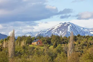 A mountain cabin with the Andes snowy peaks in background, near the Carrileufu River, Cholila, Chubut, Patagonia A mountain cabin with the Andes snowy peaks in background, near the Carrileufu River, Cholila, Chubut, Patagonia