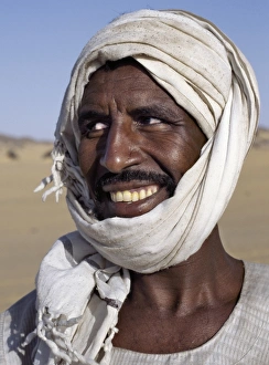 A Nubian man wearing a white turban smiles broadly at his friend A Nubian man wearing a white turban smiles broadly at his friend