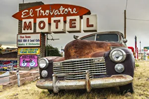 Old rusted Pontiac car and vintage motel sign behind along the historic U.S. Route 66 Old rusted Pontiac car and vintage motel sign behind along the historic U.S. Route 66