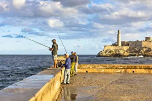 People fishing early in the morning on the Malecon, with Castillo De Los Tres Reyes Del People fishing early in the morning on the Malecon, with Castillo De Los Tres Reyes Del