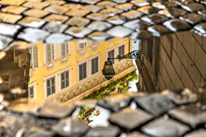 Picturesque corner of the old town reflected in a puddle on a cobbled street, Rome, Lazio Picturesque corner of the old town reflected in a puddle on a cobbled street, Rome, Lazio