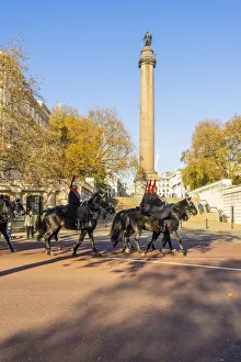 The Queens guards during the Changing of the Guard marching past the Duke of York Monument, London, England, UK The Queens guards during the Changing of the Guard marching past the Duke of York Monument, London, England, UK