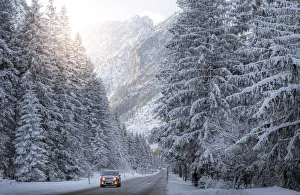 Scenic route with red car and snowy winter landscape, Dolomites Alps, Italy Scenic route with red car and snowy winter landscape, Dolomites Alps, Italy