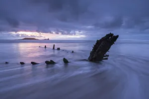 Shipwreck of the Helvetia on Rhossili Beach, looking towards WormaAAs Head at sunset Shipwreck of the Helvetia on Rhossili Beach, looking towards WormaAAs Head at sunset
