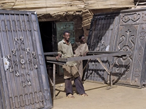 Skilled craftsmen pause beside two pairs of elaborately Skilled craftsmen pause beside two pairs of elaborately