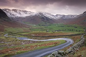 Small winding road leading into the Langdale Valley, surrounded by snow clad mountains Small winding road leading into the Langdale Valley, surrounded by snow clad mountains