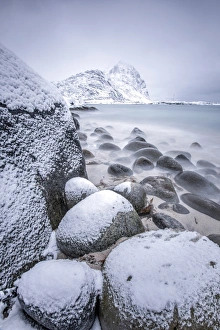 Snow covered rocks on the beach modeled by the wind surround the icy sea Pollen Vareid Snow covered rocks on the beach modeled by the wind surround the icy sea Pollen Vareid