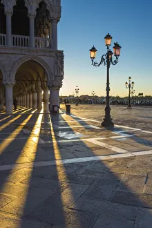 St Mark square, Venice, Veneto, Italy. Sun rays at sunrise through the arches of Palazzo St Mark square, Venice, Veneto, Italy. Sun rays at sunrise through the arches of Palazzo