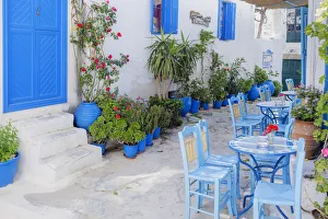 Streetside cafe tables and chairs, Amorgos, Cyclades Islands, Greece, Europe Streetside cafe tables and chairs, Amorgos, Cyclades Islands, Greece, Europe