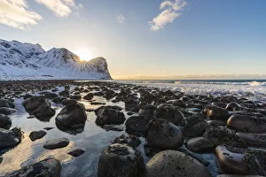 Northern Norway Landscape Prints: The sun is setting behind Helligberget peak at Unstad Beach. Vestvagoy municipality