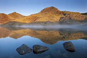 Sunlit Crib Goch and Snowdon mountains reflected in Llyn Llydaw, Snowdonia National Park Sunlit Crib Goch and Snowdon mountains reflected in Llyn Llydaw, Snowdonia National Park