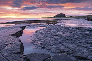 Sunrise over Bamburgh Castle from the rocky shores of Bamburgh Beach, Northumberland Sunrise over Bamburgh Castle from the rocky shores of Bamburgh Beach, Northumberland