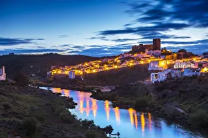 Sunset view over Guadiana River to old town with castle, Mertola, Alentejo, Portugal Sunset view over Guadiana River to old town with castle, Mertola, Alentejo, Portugal