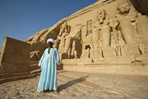 A temple guardian stands in front of the facade of Abu Simbel A temple guardian stands in front of the facade of Abu Simbel