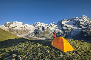 A trekker is in front of the Swiss side of Monte Rosa Massif close to Riffelsee Lake A trekker is in front of the Swiss side of Monte Rosa Massif close to Riffelsee Lake