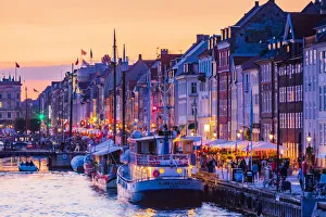 Typical buildings along Nyhavn water canal in Copenhagen at sunset, Denmark Typical buildings along Nyhavn water canal in Copenhagen at sunset, Denmark
