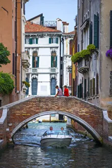 Venice, Veneto, Italy. Two boys sitting on a canals bridge Venice, Veneto, Italy. Two boys sitting on a canals bridge