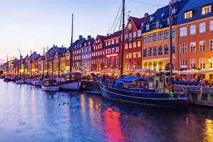 View of colored houses reflecting in Nyhavn water canal by night in Copenhagen, Denmark View of colored houses reflecting in Nyhavn water canal by night in Copenhagen, Denmark