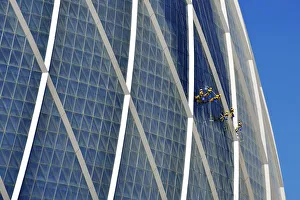 Window cleaners hanging on The Coin building Aldar headquarters, one of the largest Window cleaners hanging on The Coin building Aldar headquarters, one of the largest
