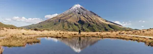 A woman enjoying the view of the Taranaki volcano in New Zealand northern island A woman enjoying the view of the Taranaki volcano in New Zealand northern island