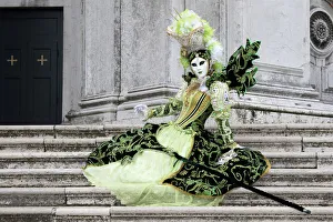 Woman in green costume at Carnival time sitting on steps at Salute, Venice, Veneto, Italy Woman in green costume at Carnival time sitting on steps at Salute, Venice, Veneto, Italy