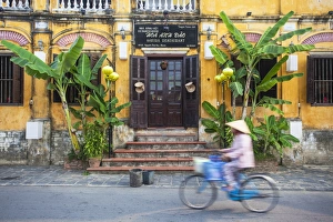 Woman riding bicycle past restaurant, Hoi An (UNESCO World Heritage Site), Quang Ham Woman riding bicycle past restaurant, Hoi An (UNESCO World Heritage Site), Quang Ham
