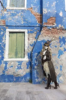 Woman in steampunk costume posing in front of old blue house, Burano Island, Venice Woman in steampunk costume posing in front of old blue house, Burano Island, Venice
