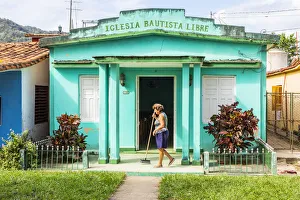 A woman sweeping the porch of her house in Vinales, Pinar del Rio Province, Cuba A woman sweeping the porch of her house in Vinales, Pinar del Rio Province, Cuba