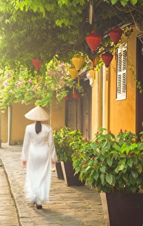 Woman wearing Ao Dai dress walking along street, Hoi An (UNESCO World Heritage Site) Woman wearing Ao Dai dress walking along street, Hoi An (UNESCO World Heritage Site)