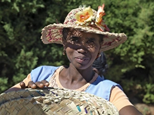 A woman wearing a decorated Malagasy hat sells baskets in Ambalavao market A woman wearing a decorated Malagasy hat sells baskets in Ambalavao market