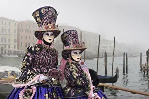 Two women in costume at Carnival time near Grand canal in mist, Venice, Veneto, Italy Two women in costume at Carnival time near Grand canal in mist, Venice, Veneto, Italy